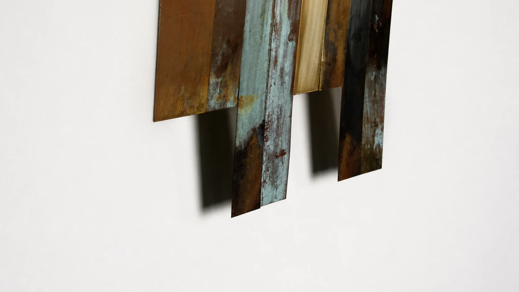 Detalle de piezas de metal y sus sombras sobre la pared
