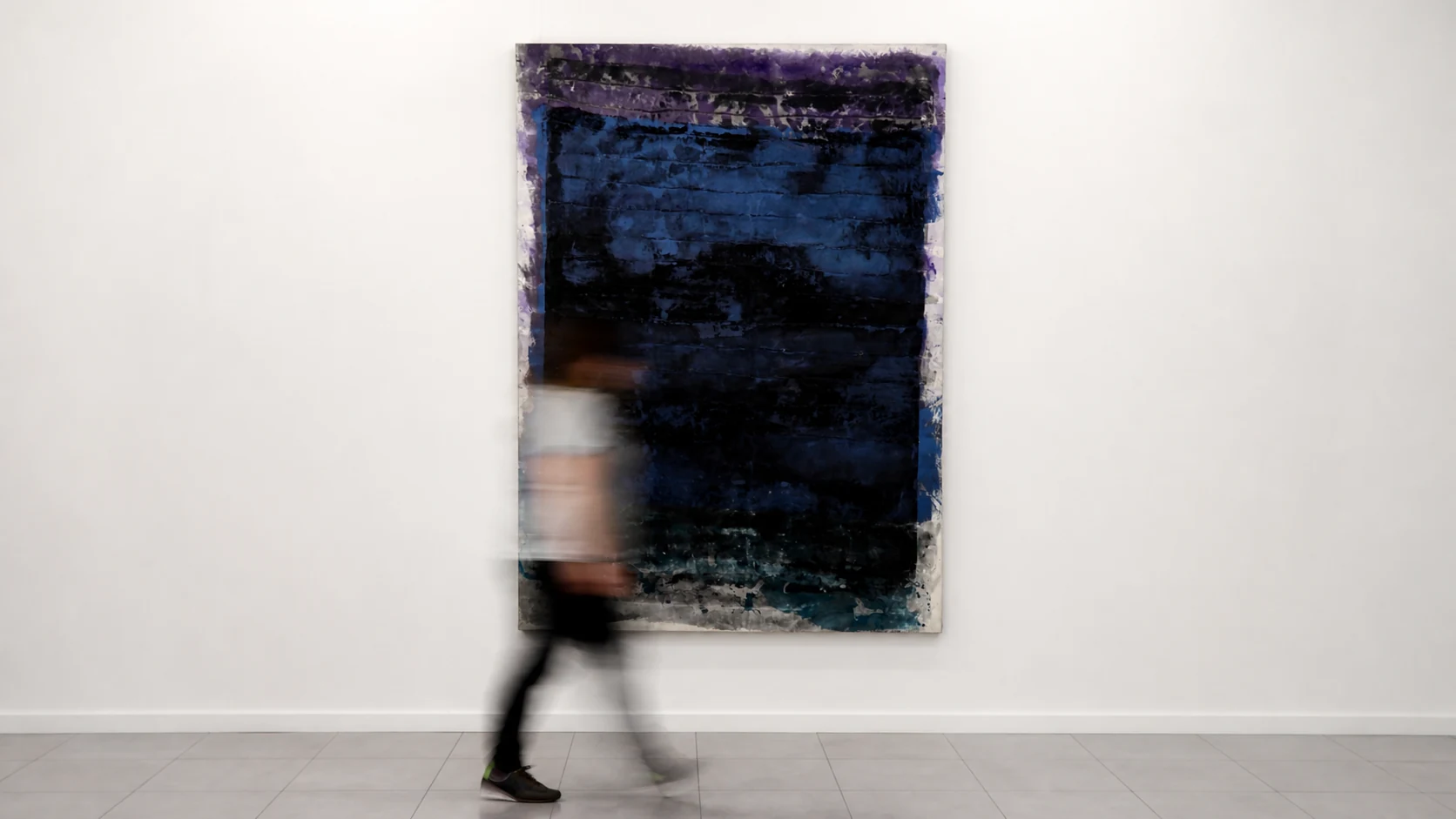 Figura en movimiento frente a una obra azul oscuro