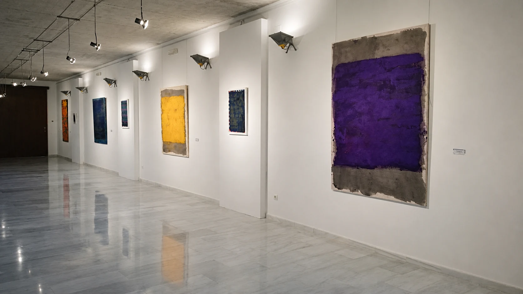 Vista de sala con una gran obra violeta y otras pinturas de Mar Ortega