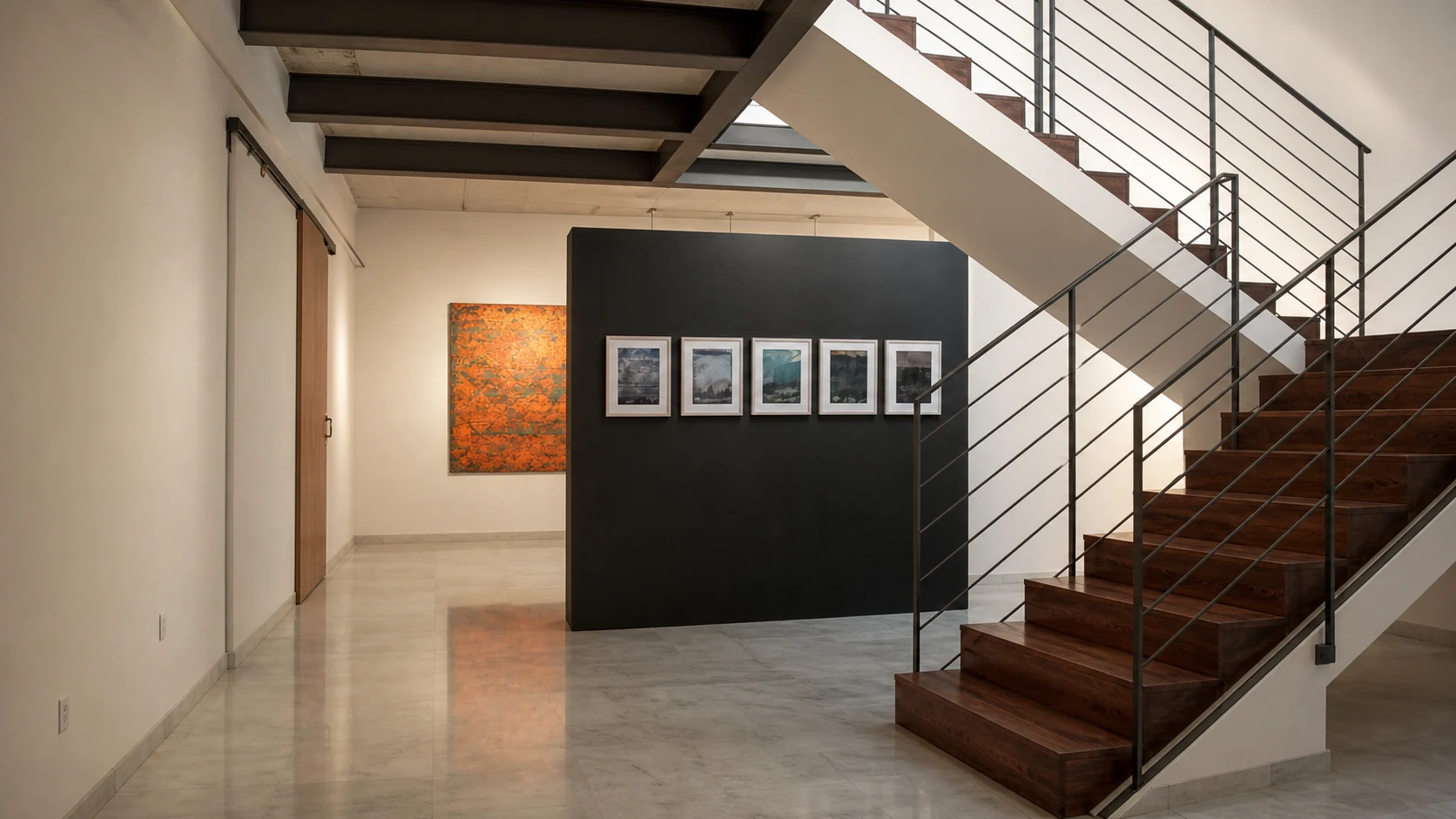 Vista de exposición con obras, panel negro y escalera de madera